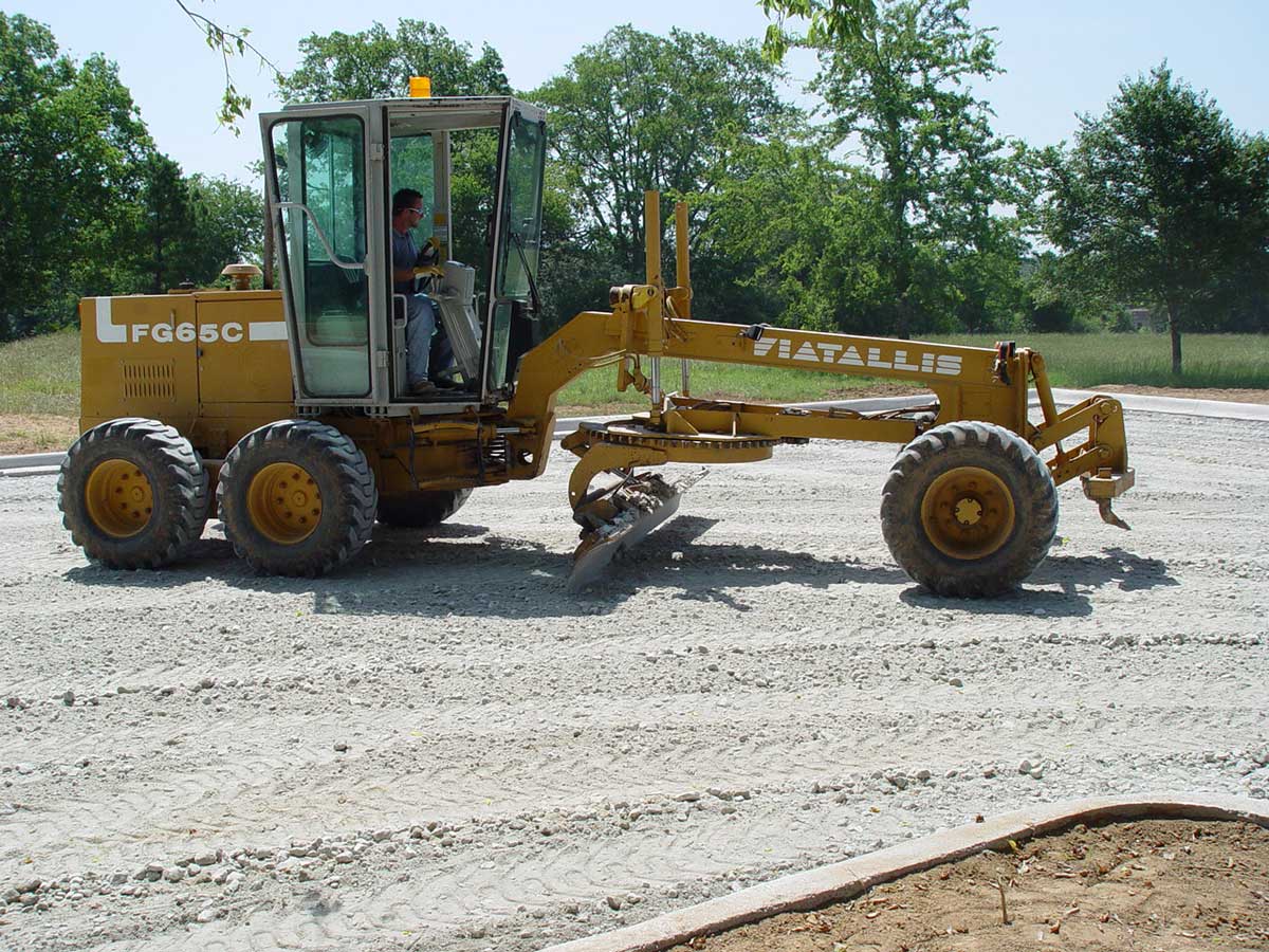 Pro-Pave operator grading sub-surface in preparation for asphalt